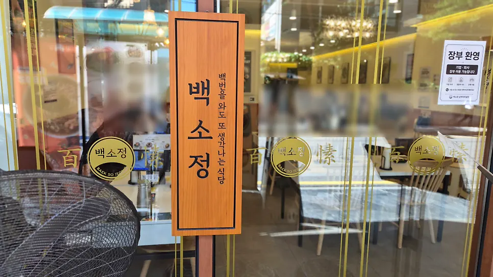 Glass door with a wooden sign board and gold logo