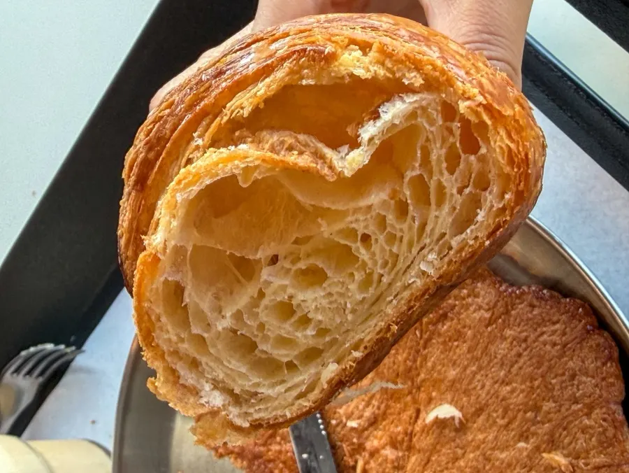 바다 앞 테이블에 놓인 커피와 빵