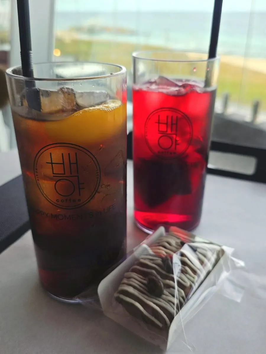 Two drinks at a window seat overlooking the sea