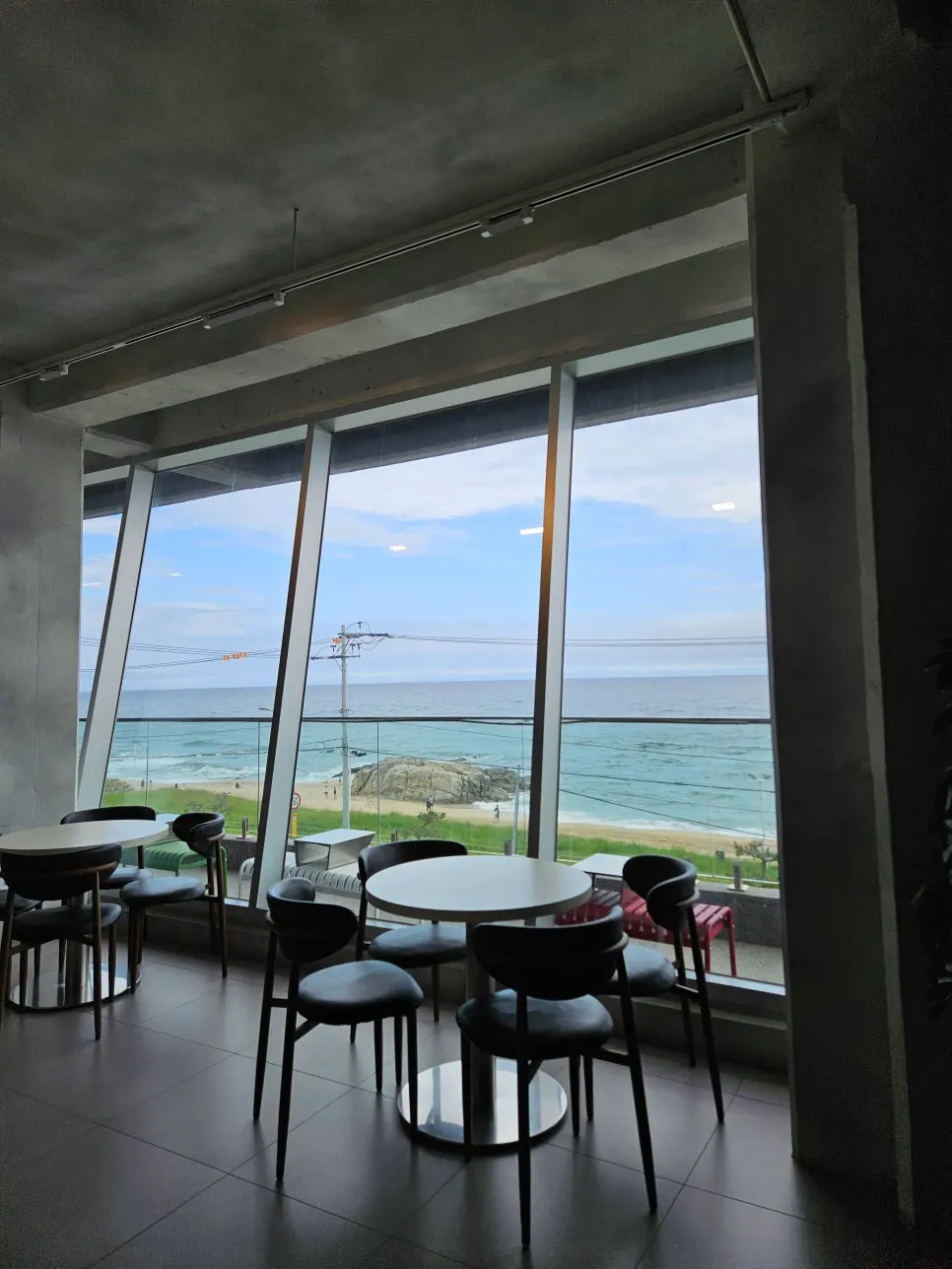 Ocean view through Baegya Coffee's floor-to-ceiling windows