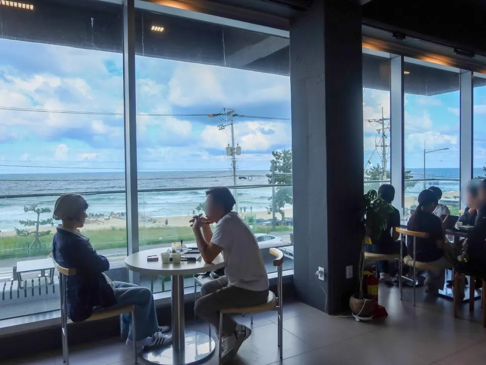 The Gangneung sea visible in one sweep through the café windows
