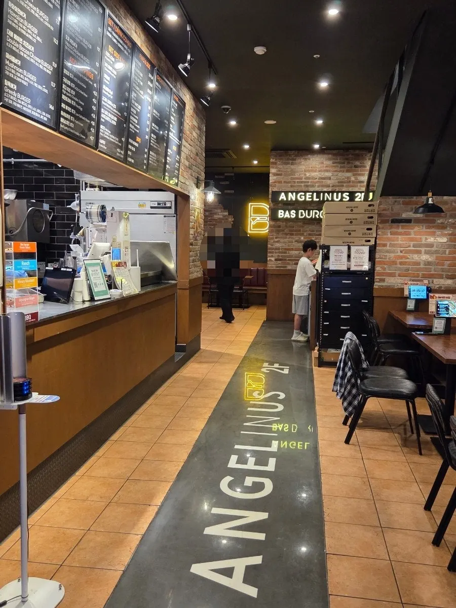 Seating inside Bas Burger with brick and wood decor