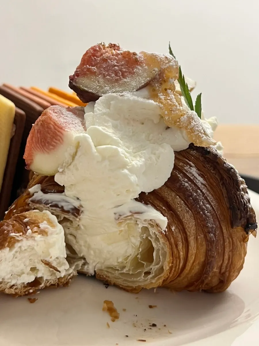 Cross-section of fig croissant filled with whipped cream