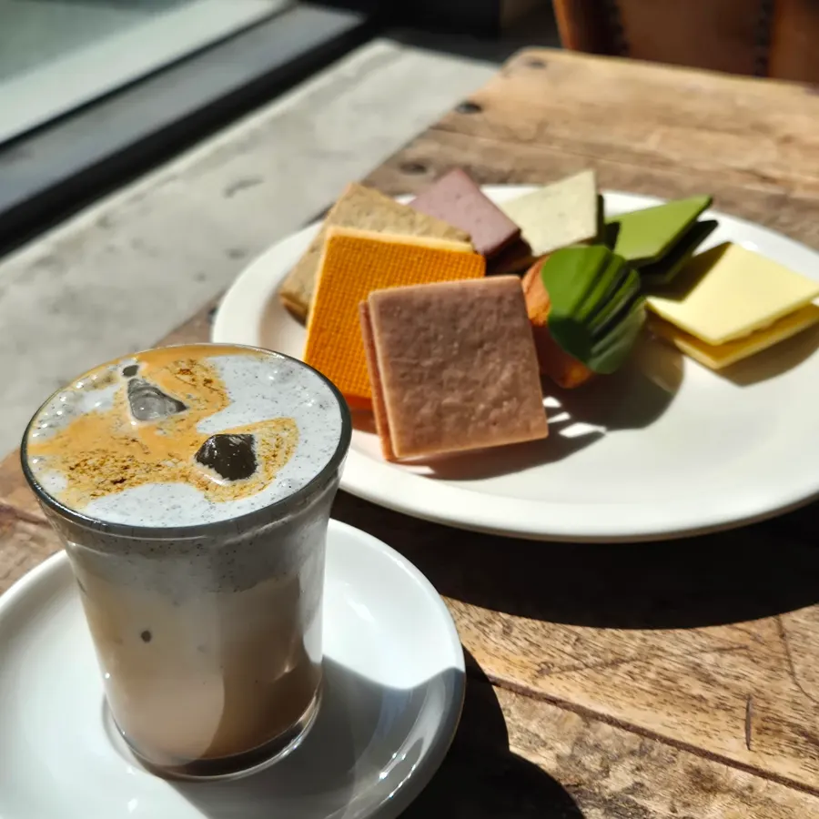 Table setting with black sesame latte, matcha madeleine, and Gangnam Sand set