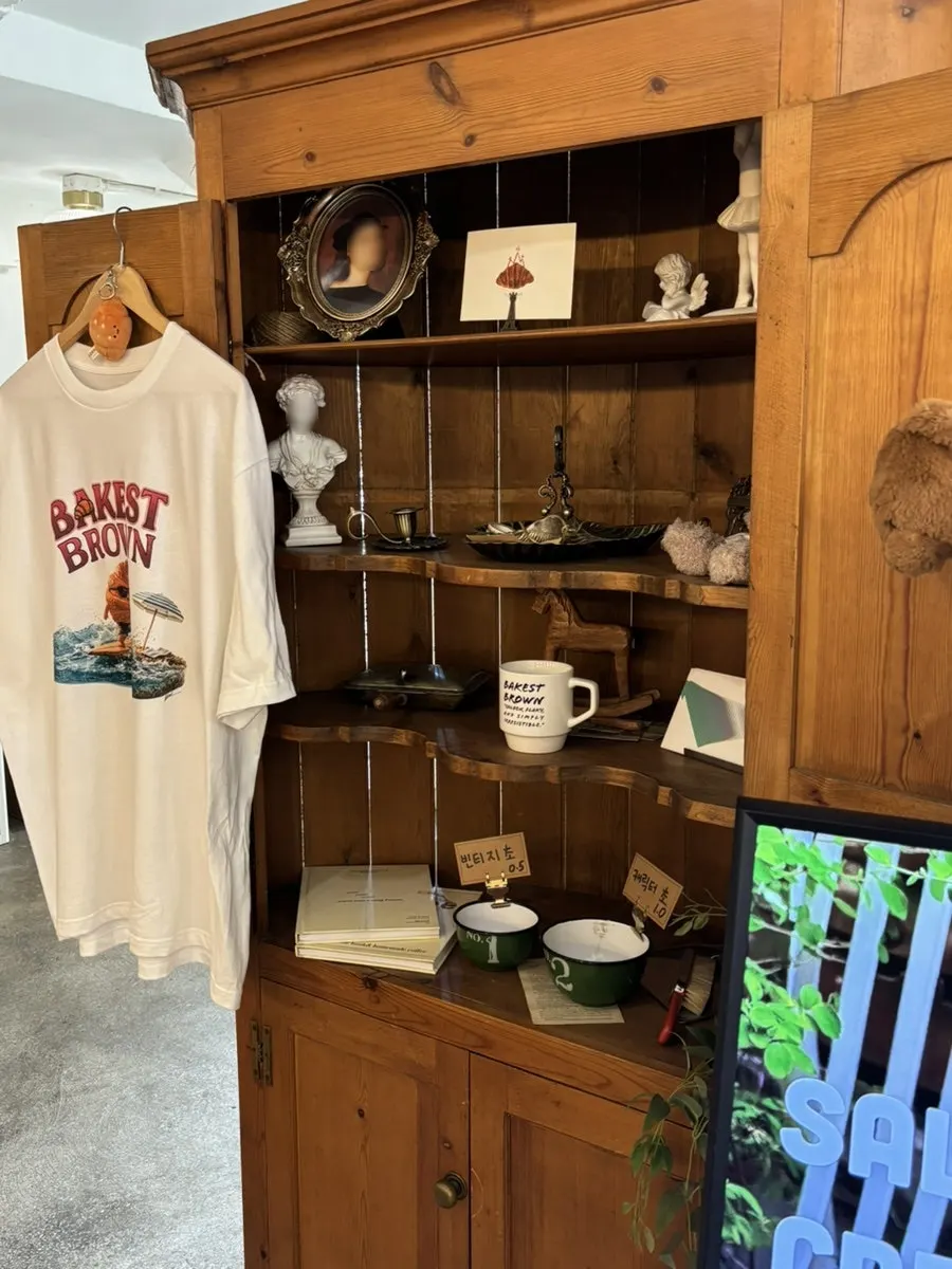 Café goods display including t-shirts and mugs