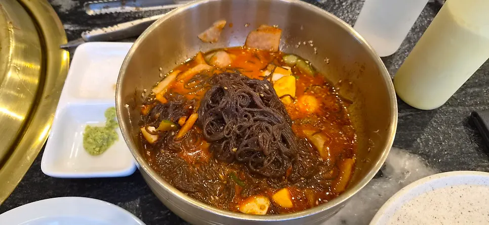 A bowl of naengmyeon eaten alongside the meat
