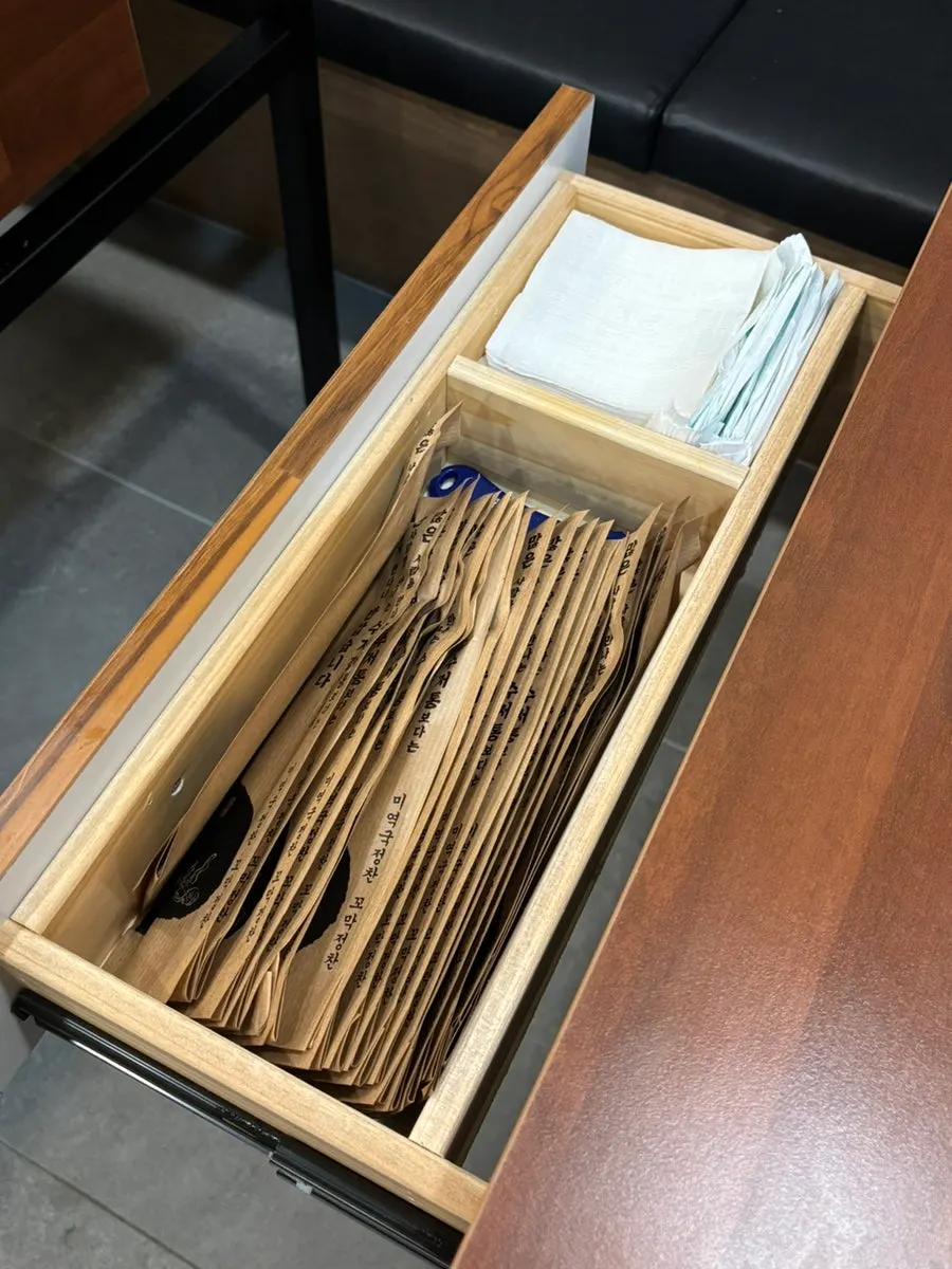 Table drawer containing utensils and wet wipes