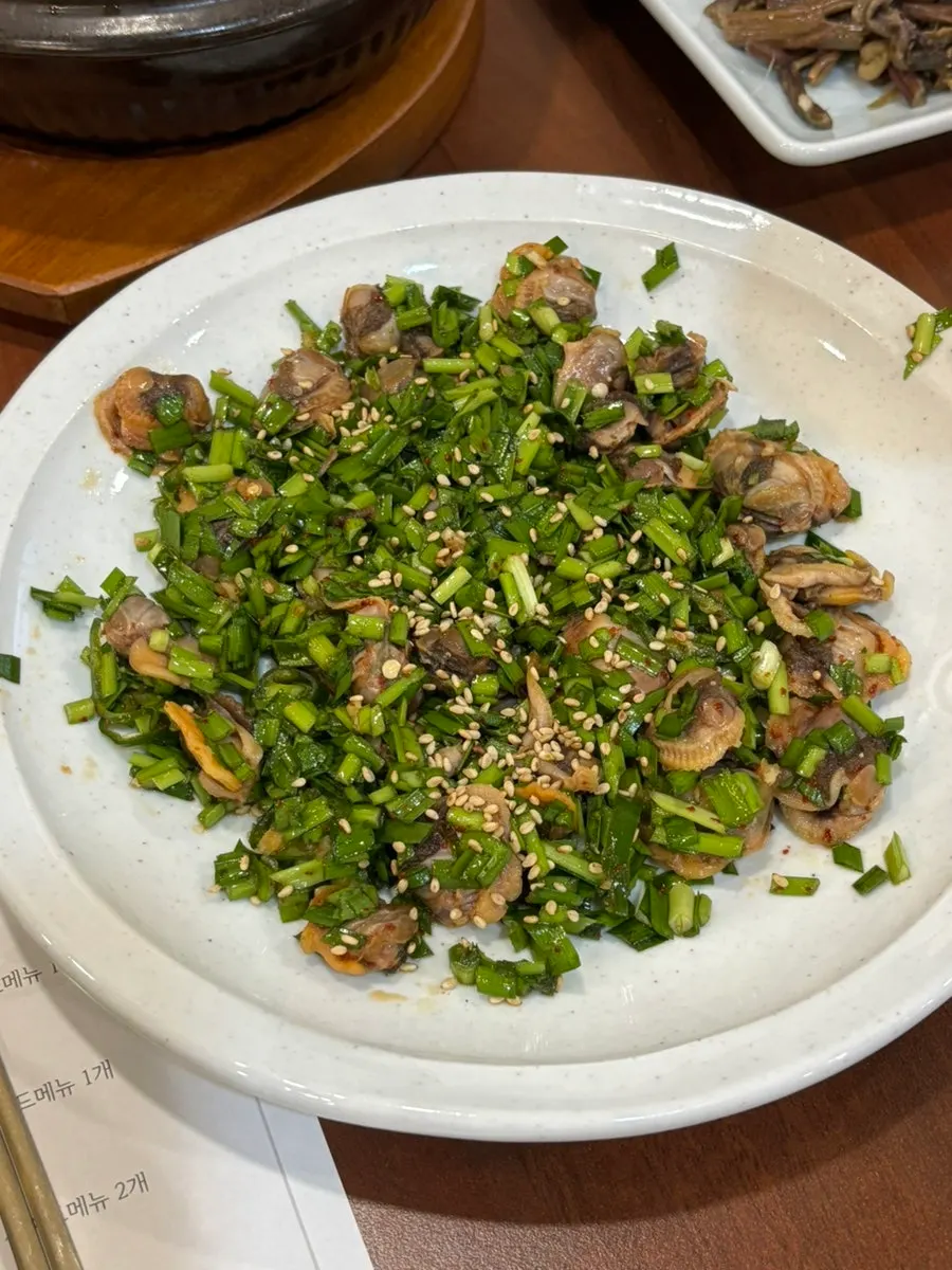 Cockle bibim topped with chives and sesame seeds