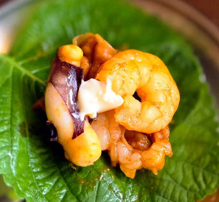 Perilla leaf wrap topped with octopus, beef intestine, and shrimp
