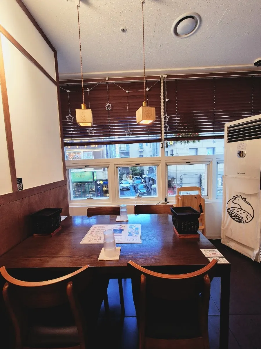 Wood-toned tables and pendant lighting inside the restaurant