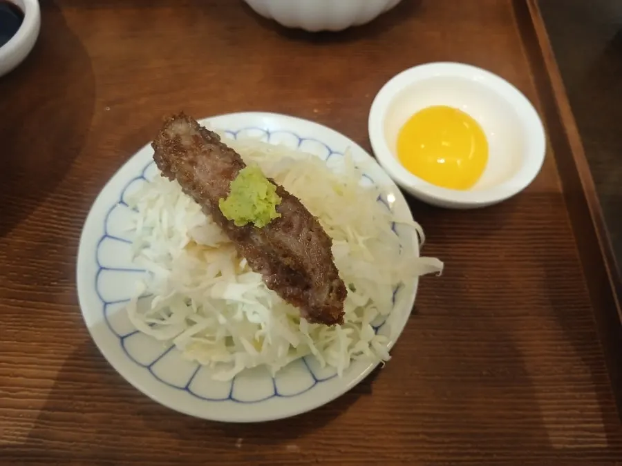A piece of gyukatsu topped with wasabi
