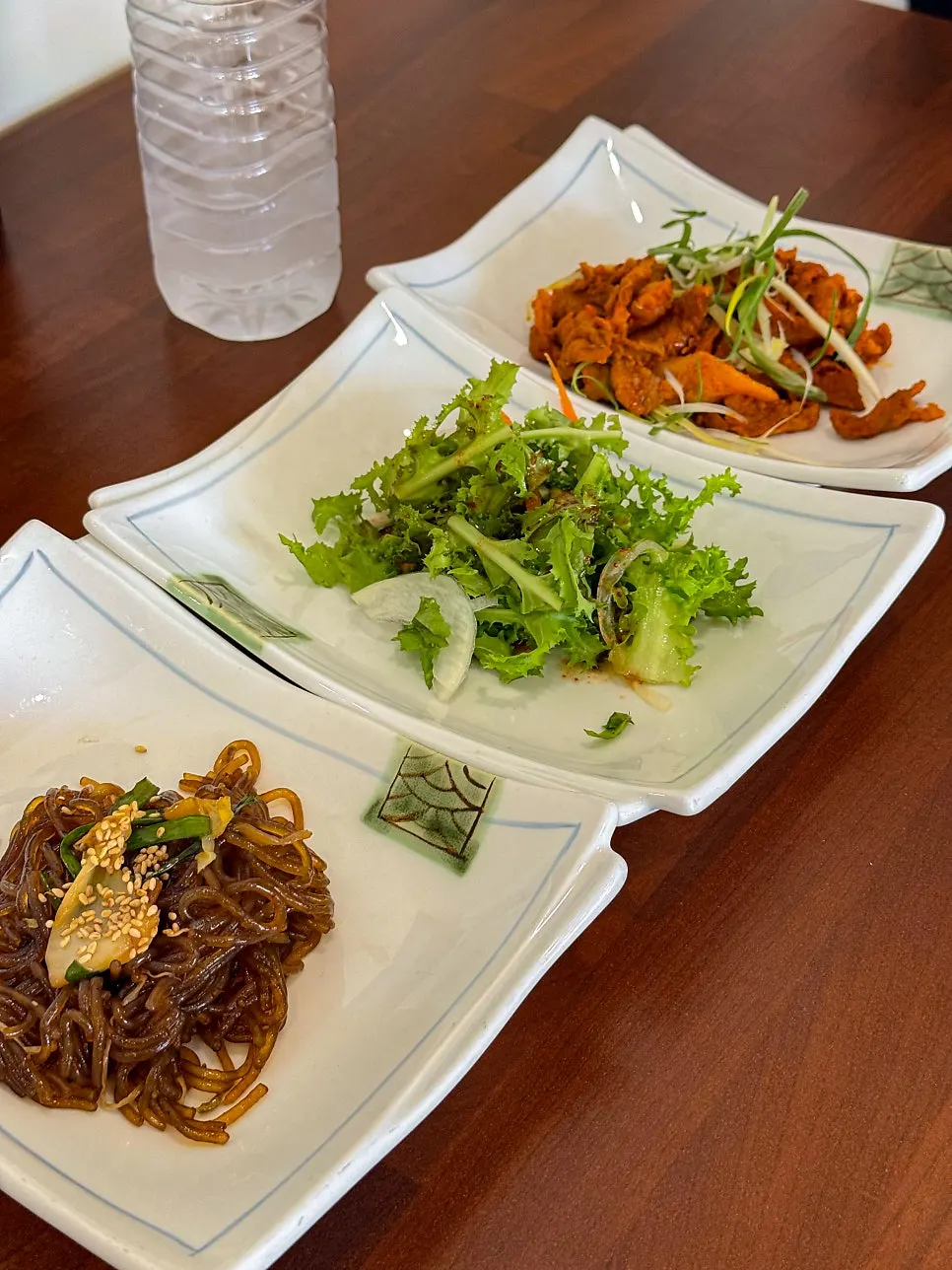 Plate of japchae, salad, and stir-fried pork