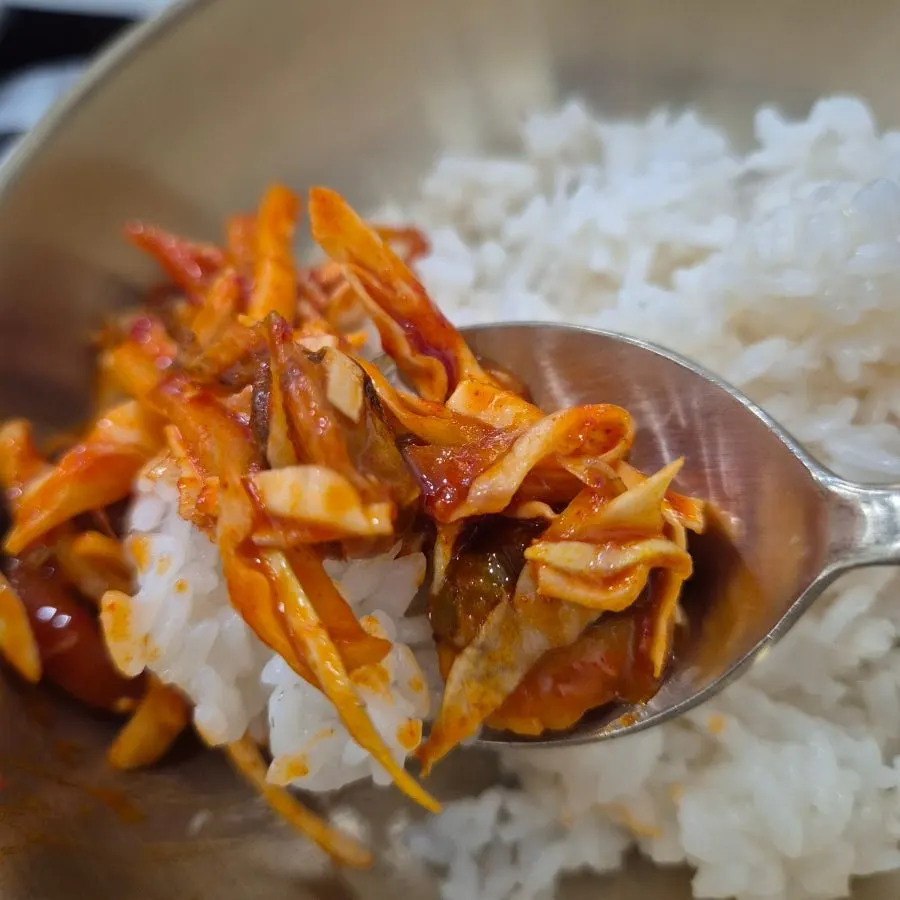 A spoonful of vinegared cockle salad on rice