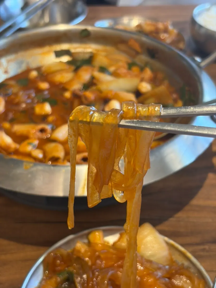 Nakgopsae and glass noodles served on a wide side plate