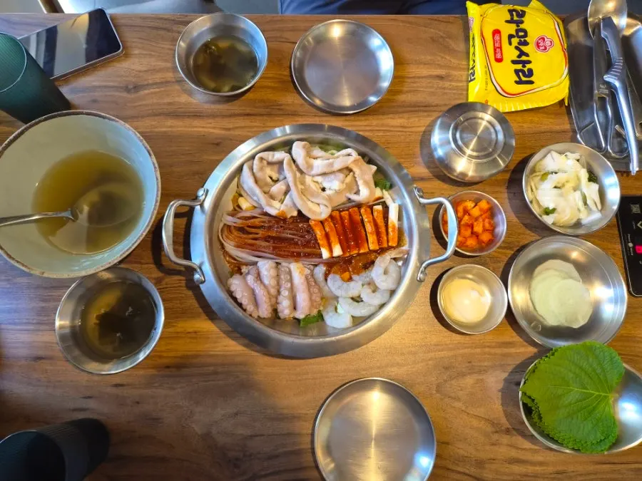 Octopus, beef tripe, shrimp, rice cake, and glass noodles neatly arranged in the beef tripe nakgopsae pot
