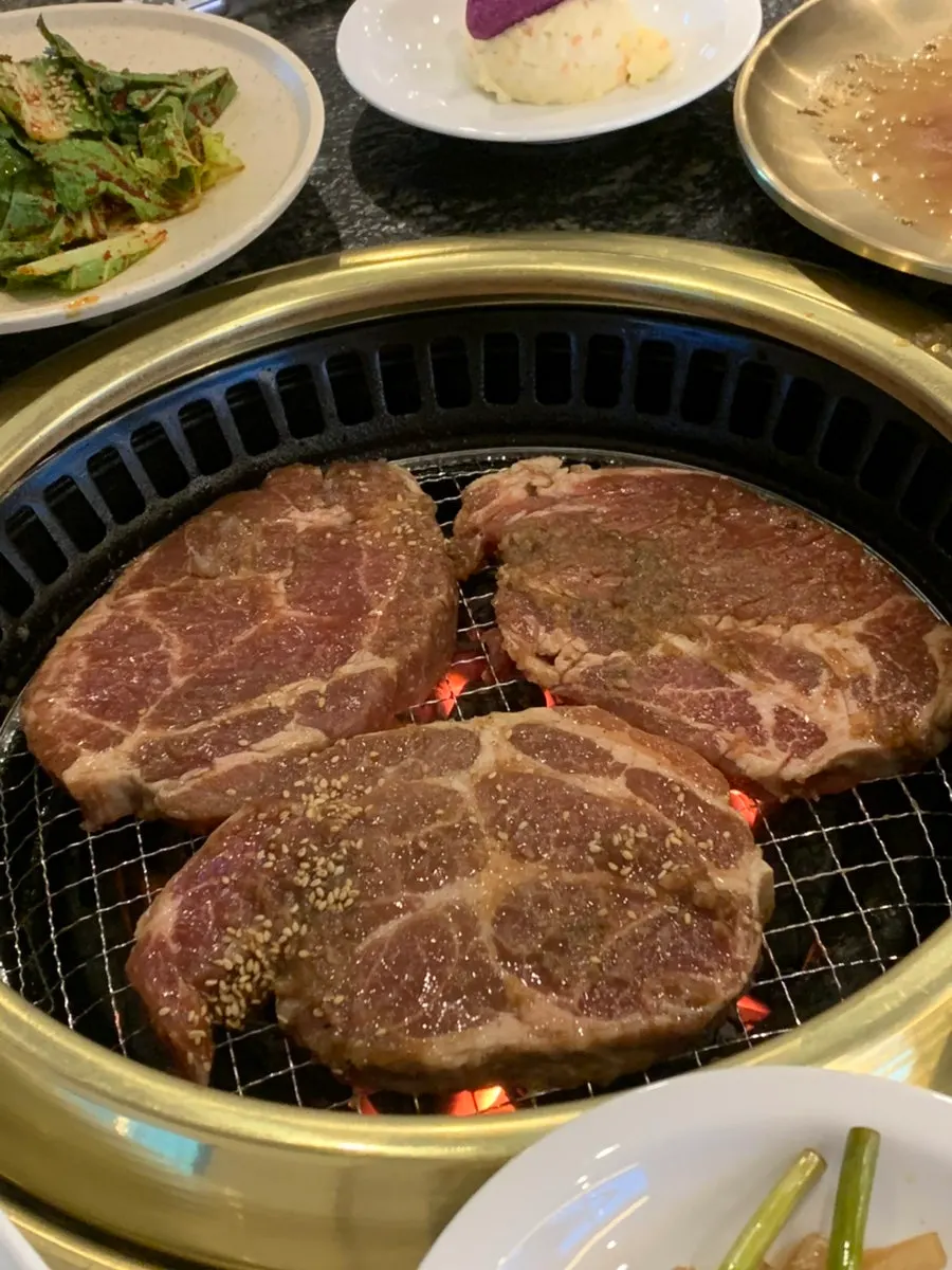 Staff member grilling marinated pork ribs on the grill