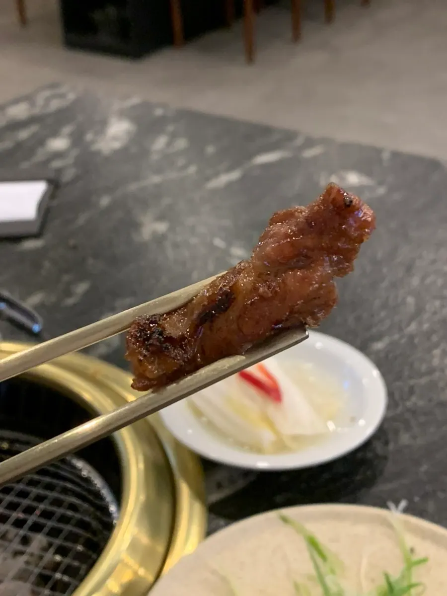 A piece of pork ribs picked up with chopsticks