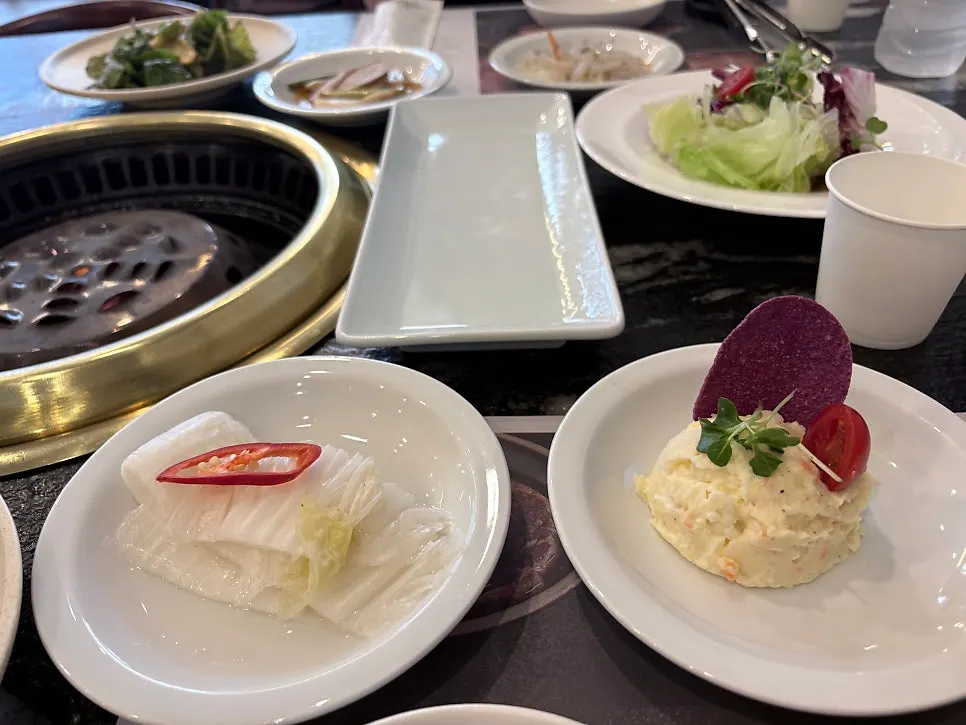 Side dishes including scallion salad and white kimchi