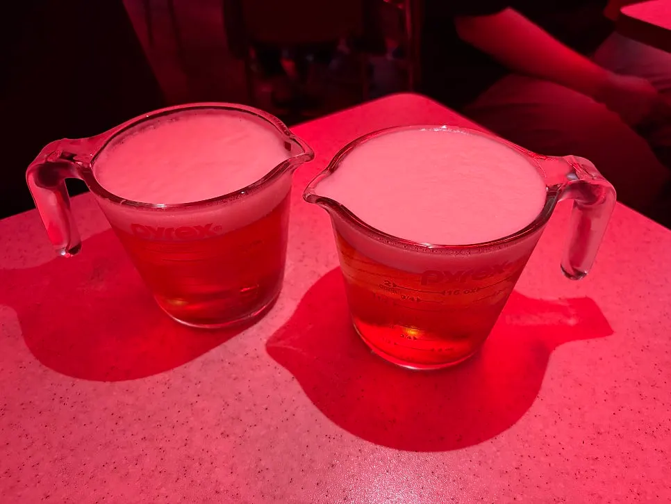 A table with chicken and draft beer set out together