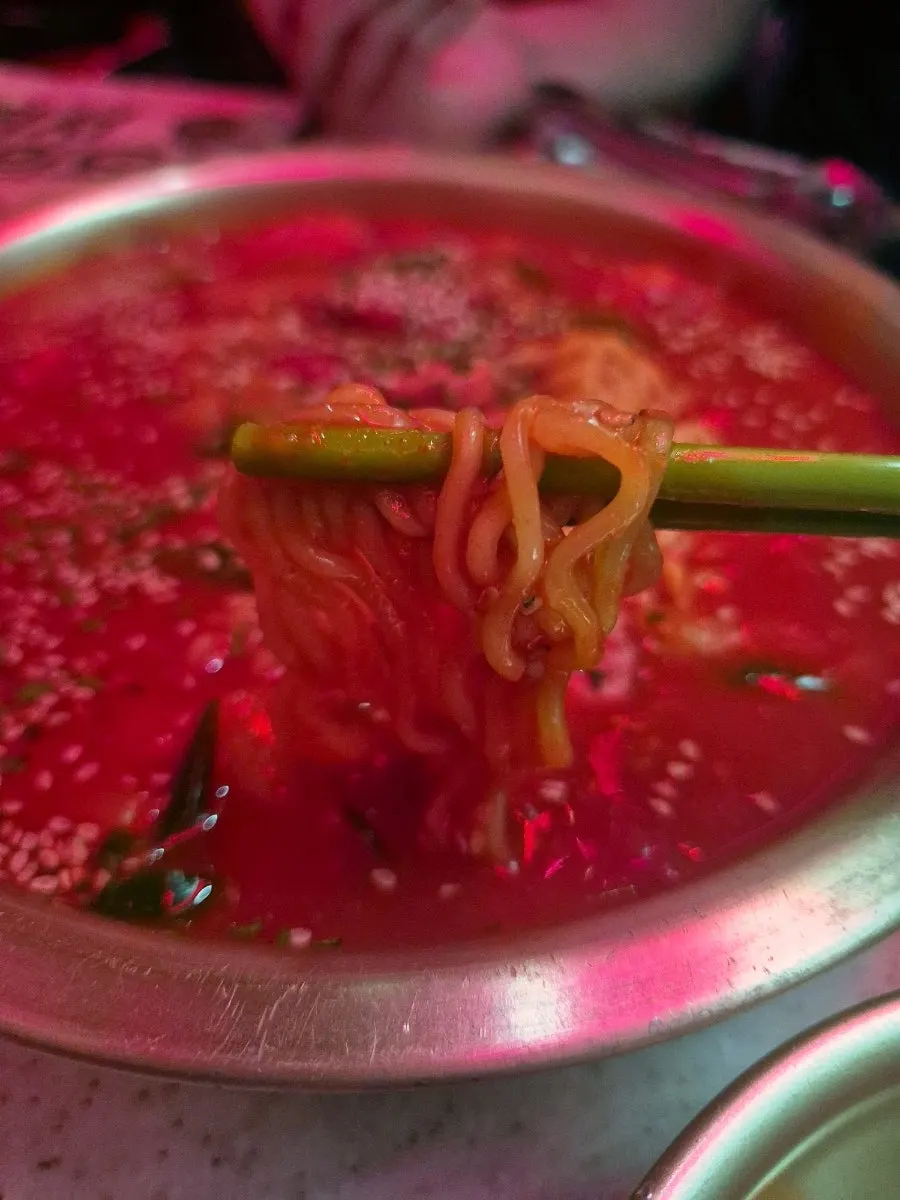 A bite of rice cake and ramen noodle together