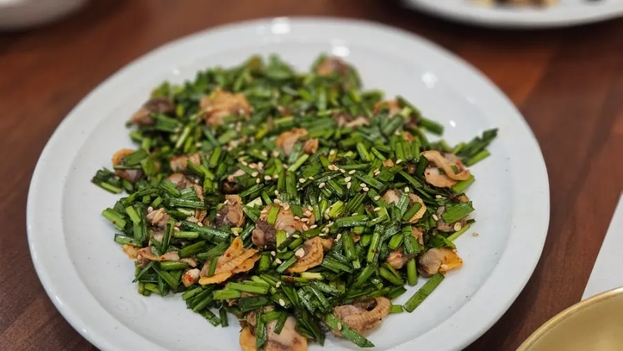 Plates of japchae, pork stir-fry, and other basic side dishes