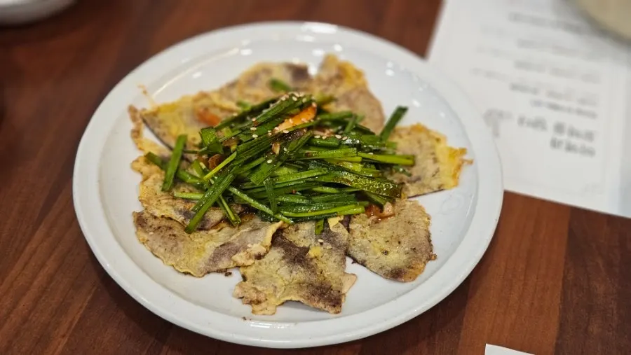 Lineup of namul, pickled vegetables, and jellyfish salad side dishes