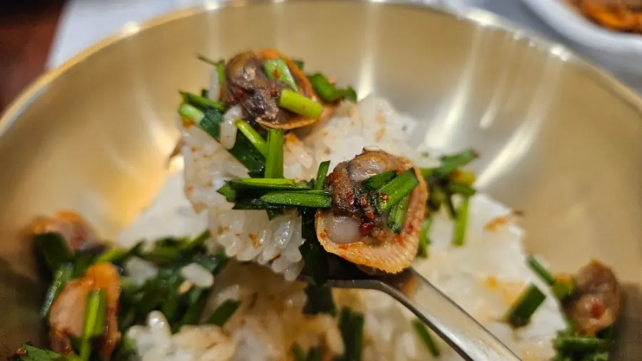 A piece of beef jeon topped with chive salad