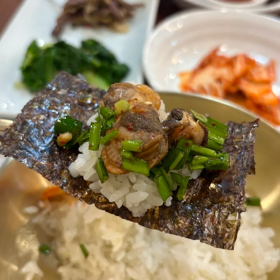 A spoonful of cockle mix stirred with rice