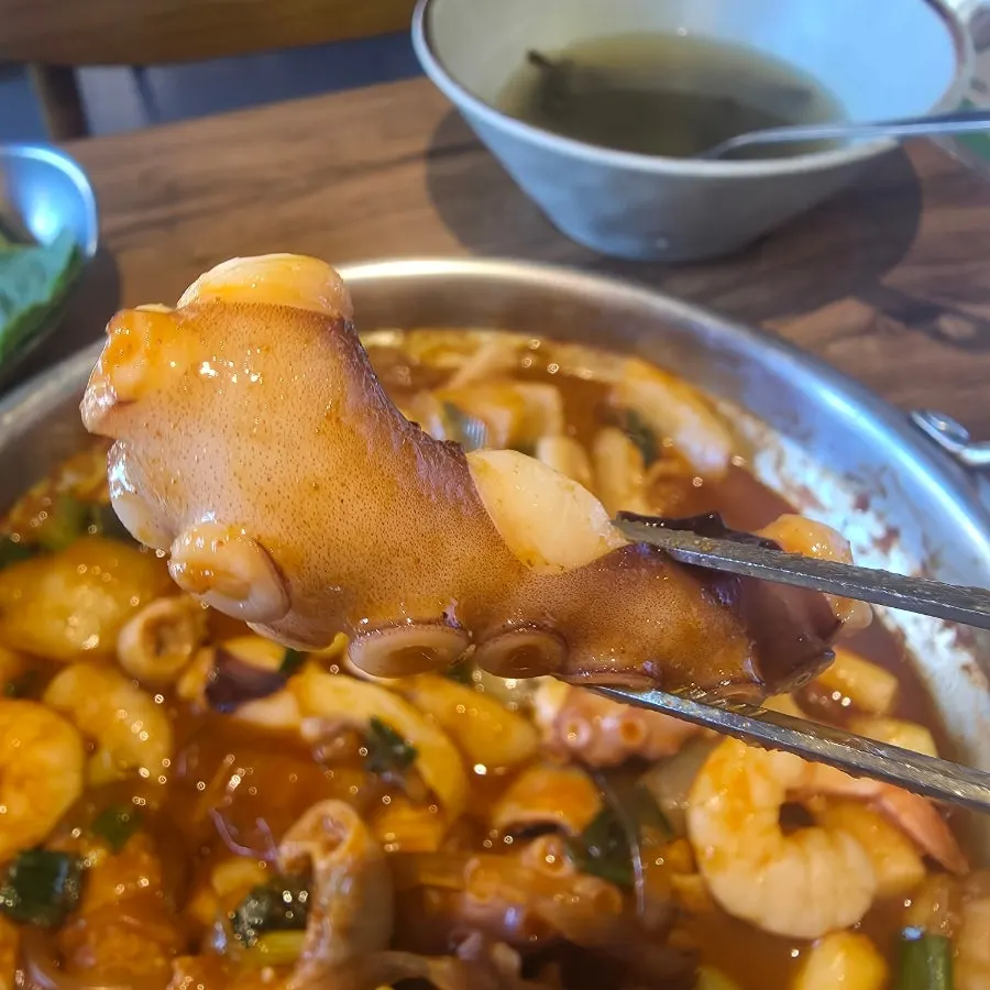 A bite of tripe and octopus picked up with chopsticks