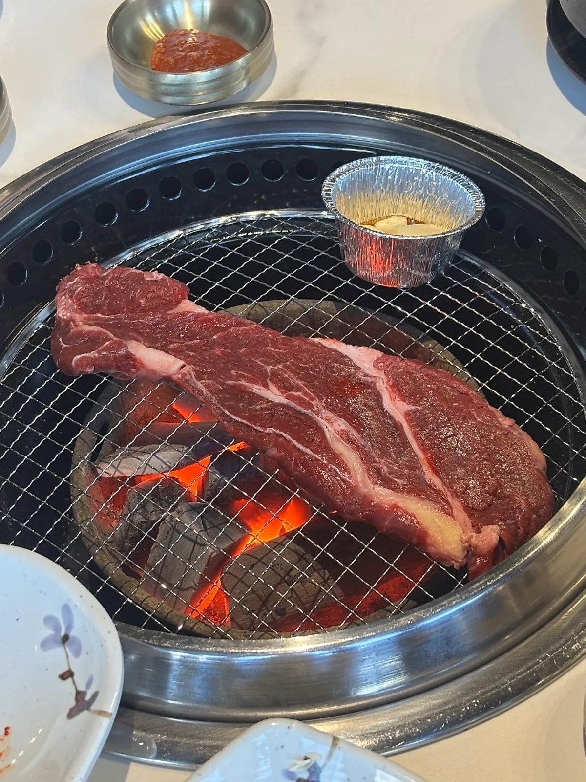 Meat and garlic placed on the charcoal grill