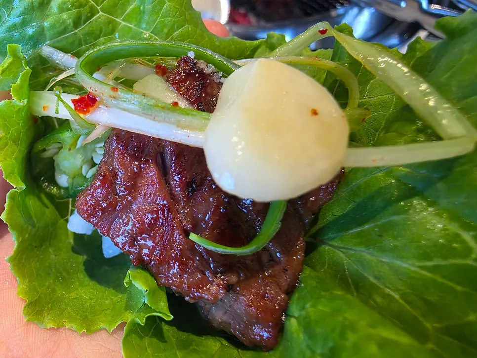 Table setting with marinated beef short ribs and ssam vegetables