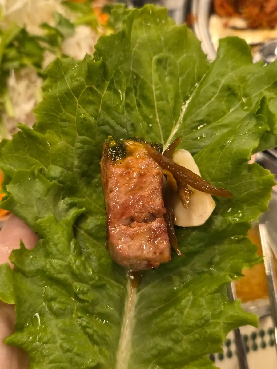Teukmoksal grilling over charcoal with side dishes