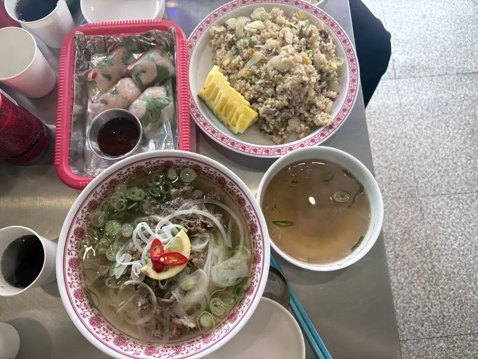 Table with beef brisket pho and fried rice side by side