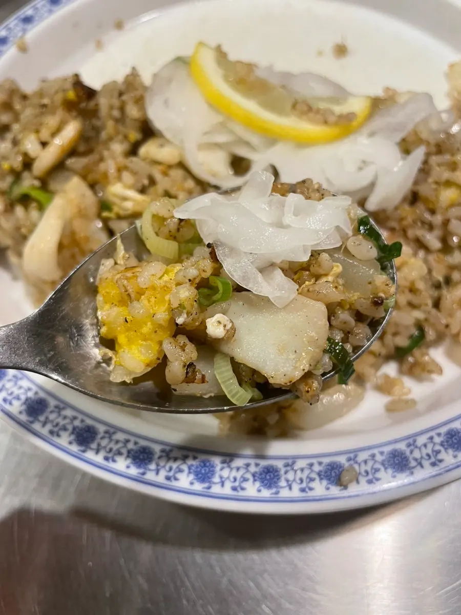 A spoonful of fried rice with squid and shrimp