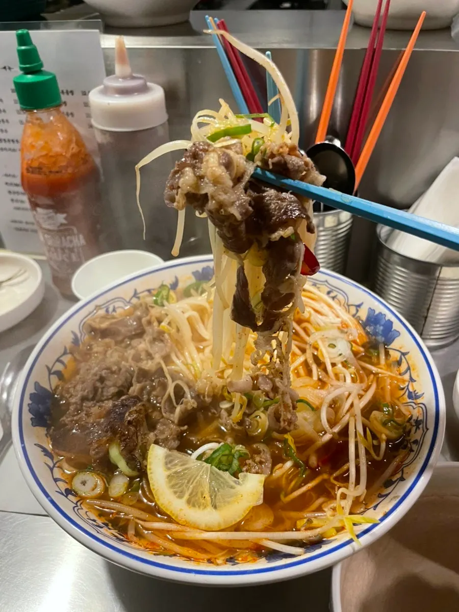 Noodles lifted from the spicy pho bowl