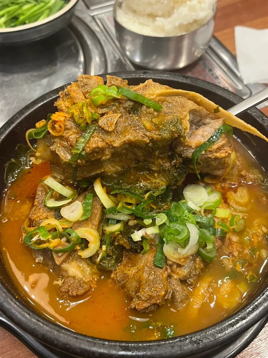 Large chunks of pork bone meat in the stone bowl of bone soup