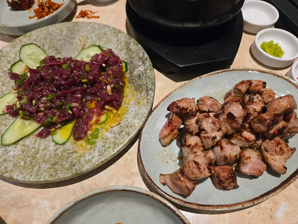 Meat cooking on the grill as staff grill it for guests