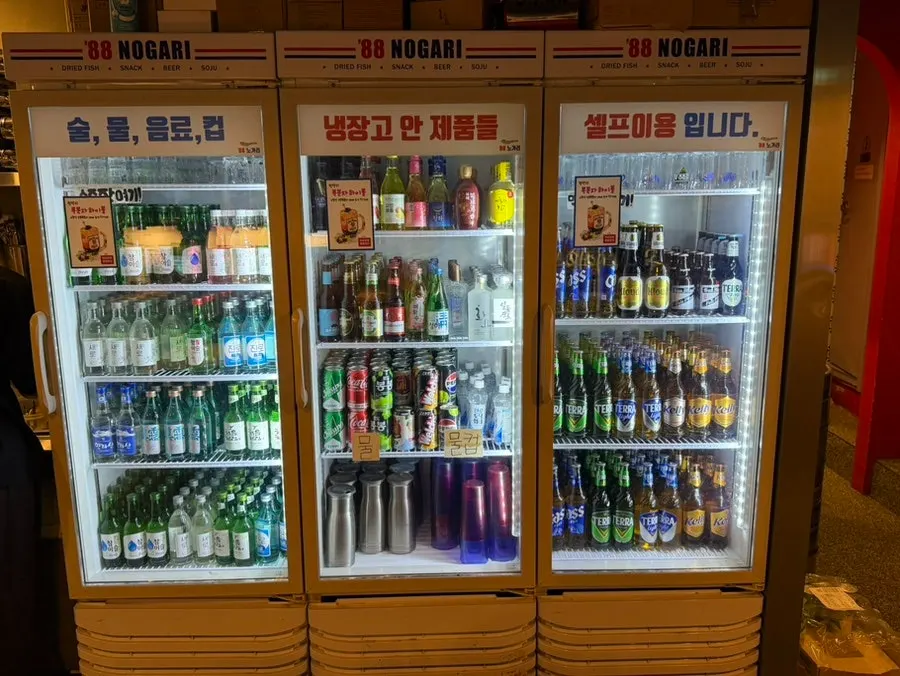 Wall lined with liquor bottles and a Kirin Ichiban draft discount sign