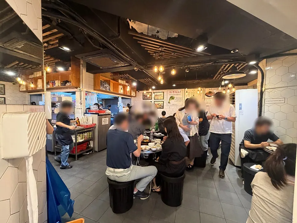 원형 철판 테이블이 놓인 노포 분위기 매장 내부
