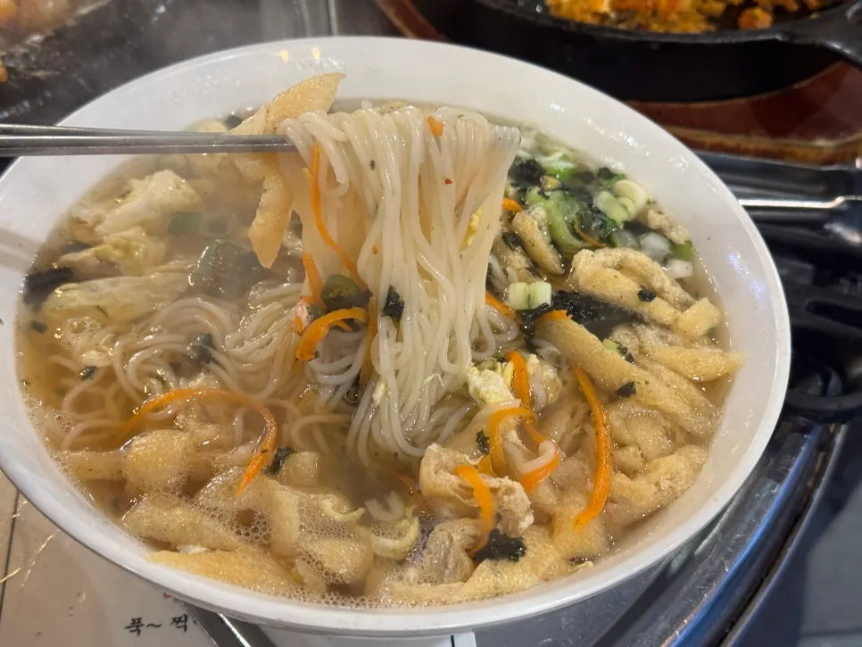 Chewy noodles lifted up from the anchovy noodle bowl
