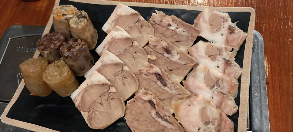 Close-up of the plate of thinly sliced boiled pork and cut sundae