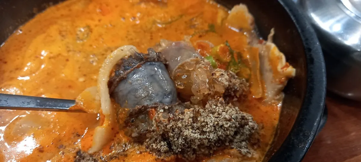 Large pork gukbap with milky broth and thinly sliced meat on top