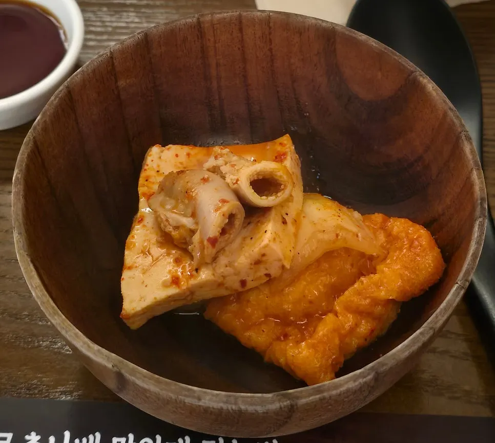 A piece of gopchang dipped in yuzu soy sauce