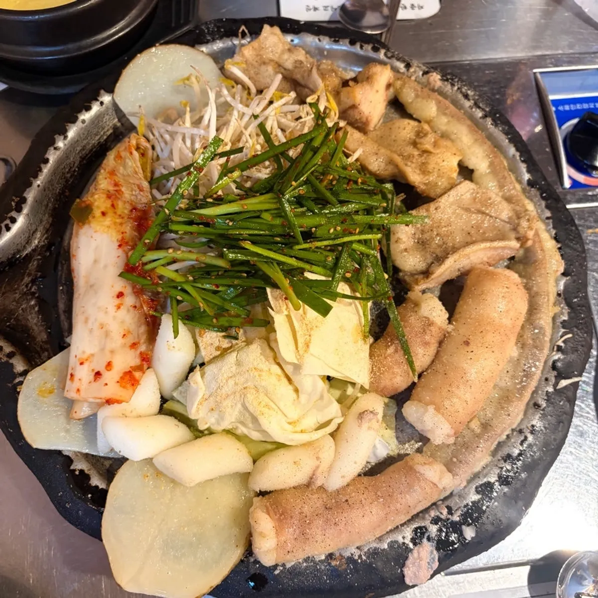 철판에 올린 곱창·대창·막창과 김치, 양배추