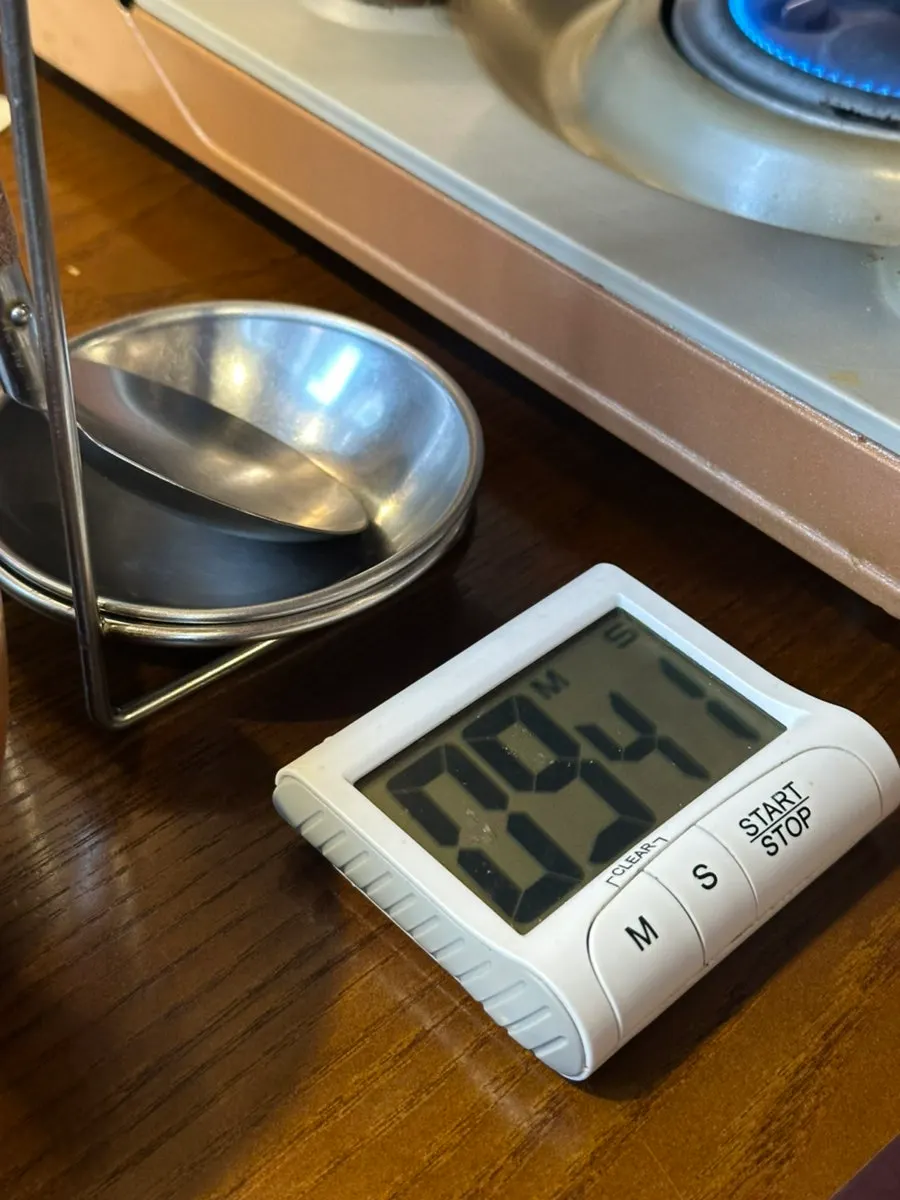 Pot of gopchang hot pot simmering alongside the 10-minute timer