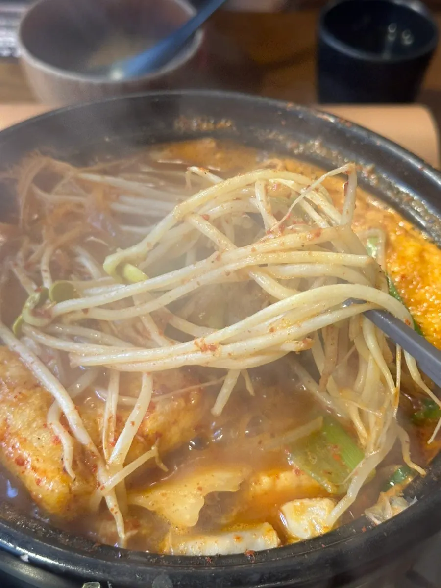 Plate with bean sprouts and fried tofu scooped from the gopchang hot pot