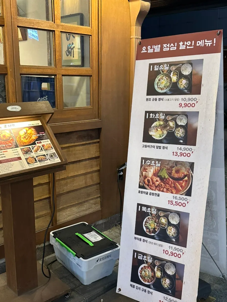 가게 앞에 놓인 요일별 점심 할인 메뉴 입간판