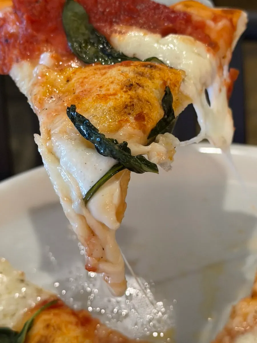 토마토 소스가 깔린 마르게리따 피자 조각