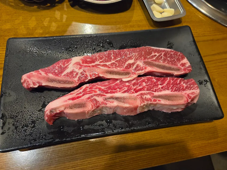 숯불 불판 위 눈꽃갈비 굽는 장면