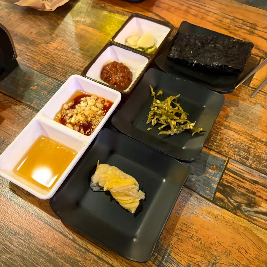 Sesame oil salt sauce, mungtigi sauce, and side dishes on the table